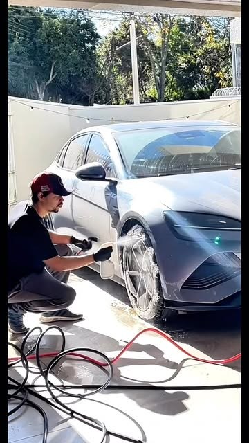 Profissional agachado lavando roda com espuma